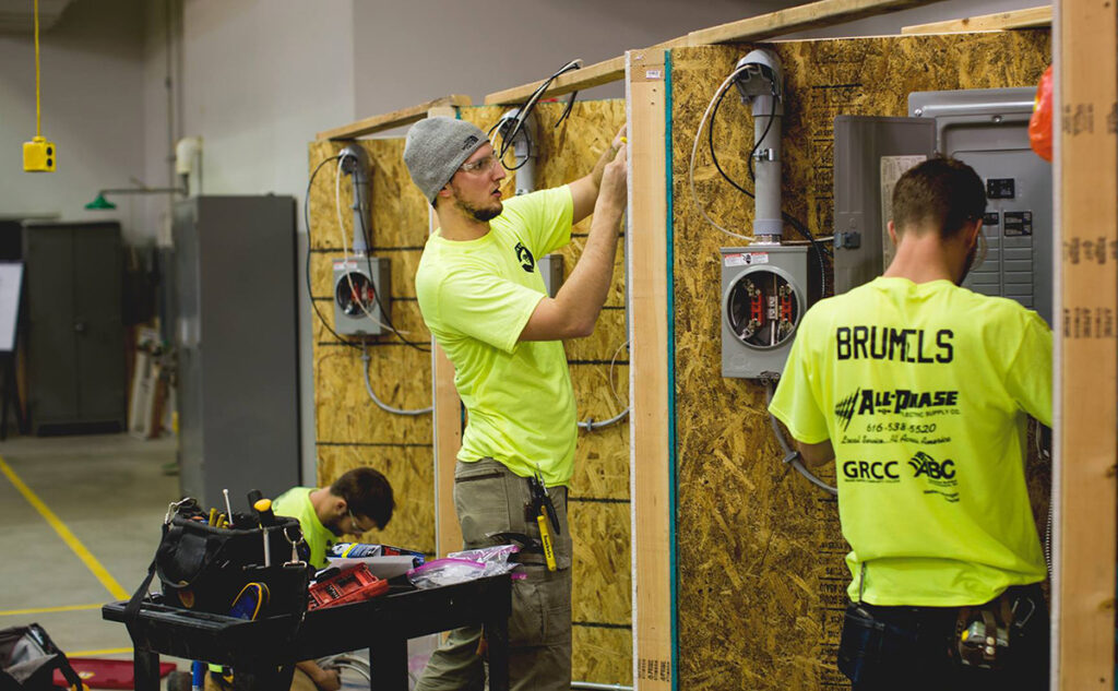 Three electricians working on breaker boxes
