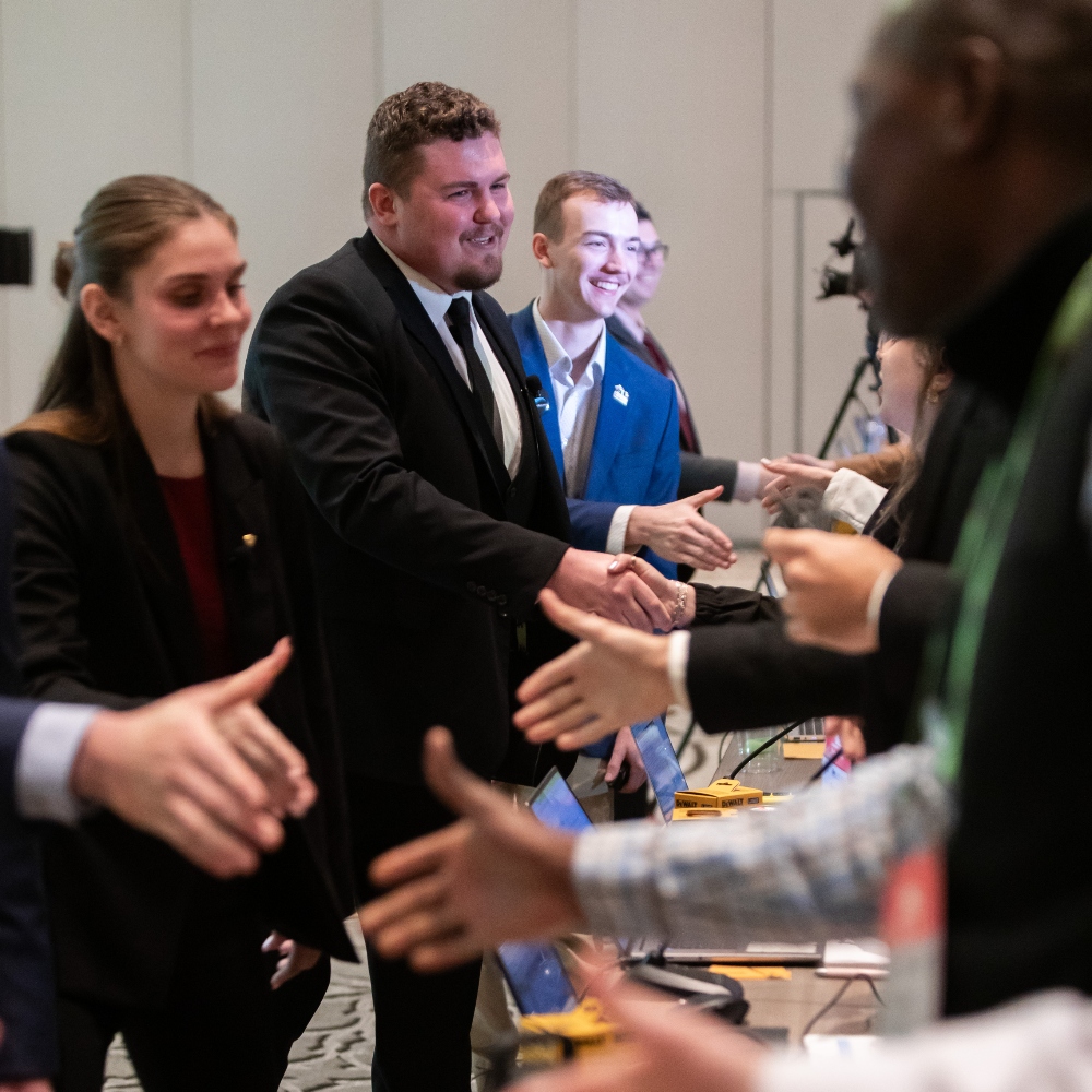 Members of the Construction Management Competition team shake hands