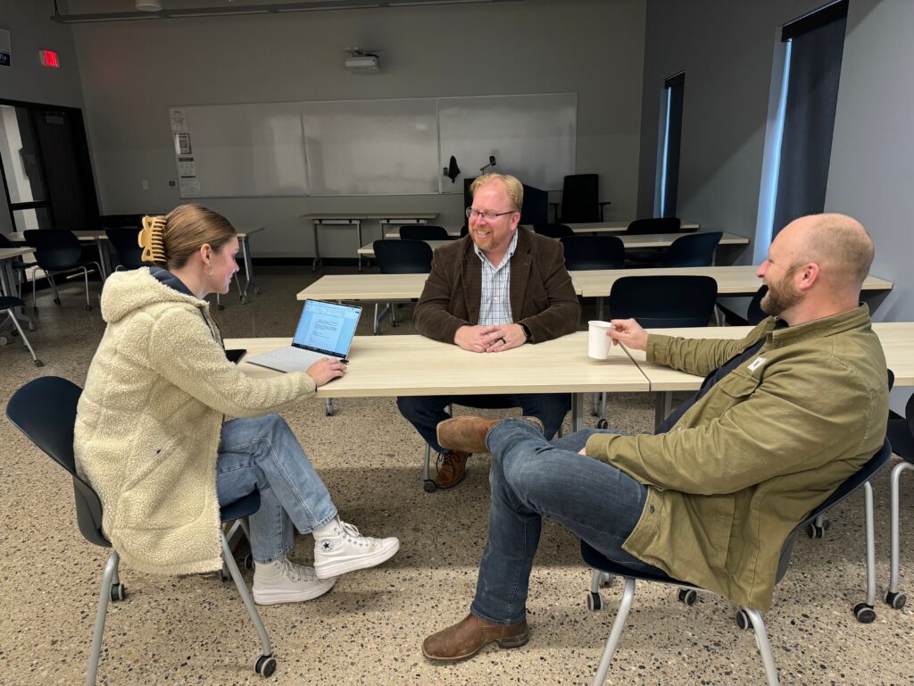 Three leaders at ABC WMC having a discussion around a table